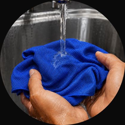 Soaking a cooling towel under a running tap