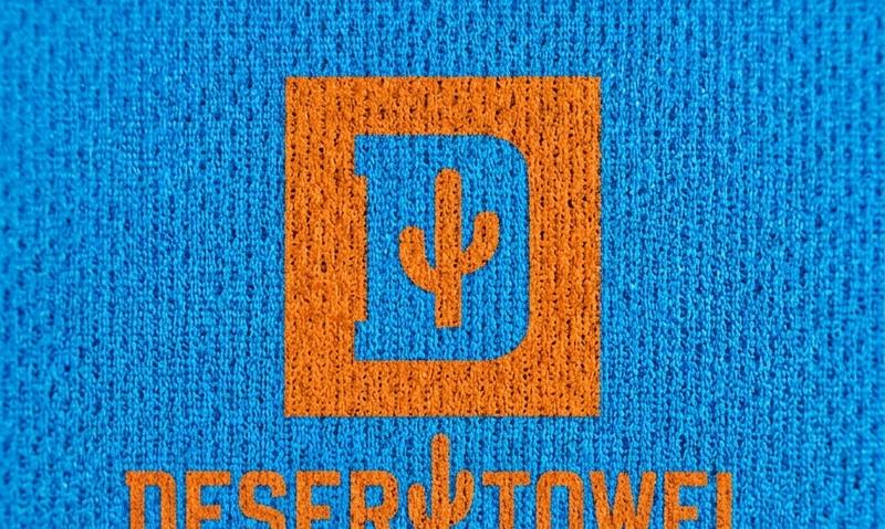 Close-up of the printed logo on a Desert Towel, the fabric weave running straight through the coloured area