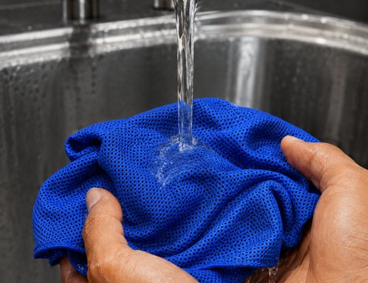 Soaking the towel under a tap