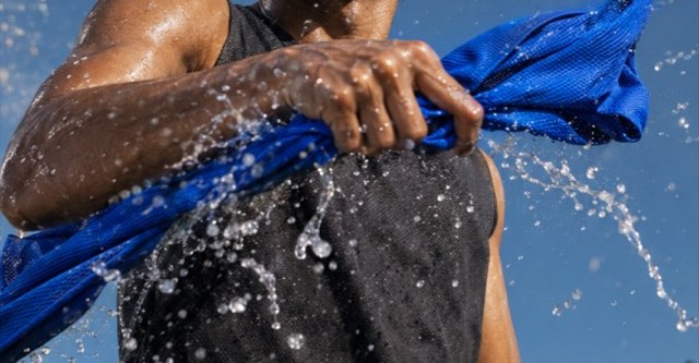 A wet blue cooling towel snapped through the air, throwing water